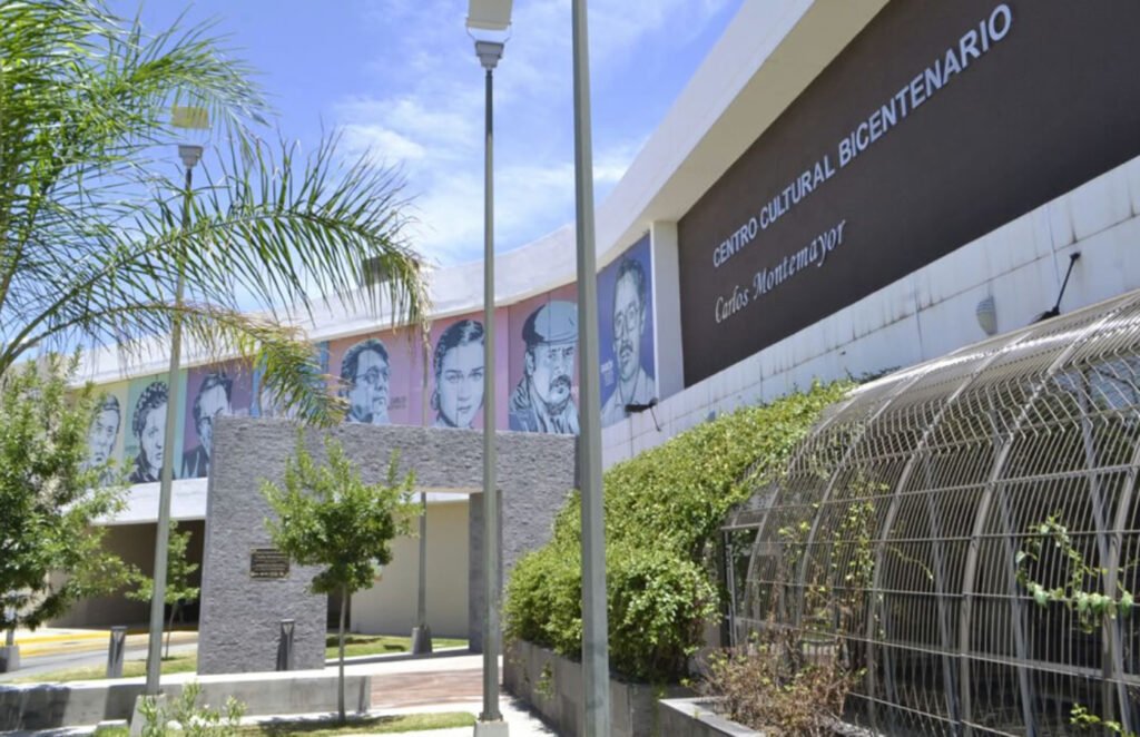 Edificio color blanco con cafe, en la parte derecha superior letras color blancas que dicen Centro cultural bicentenario Carlos Montemayor.