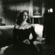 María Felix, la doña, vestida de negro y sentada en un sofá