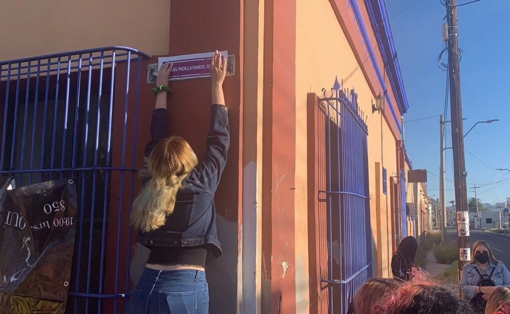 Chica cambiando el nombre de la calle en manifestación por el día de la mujer