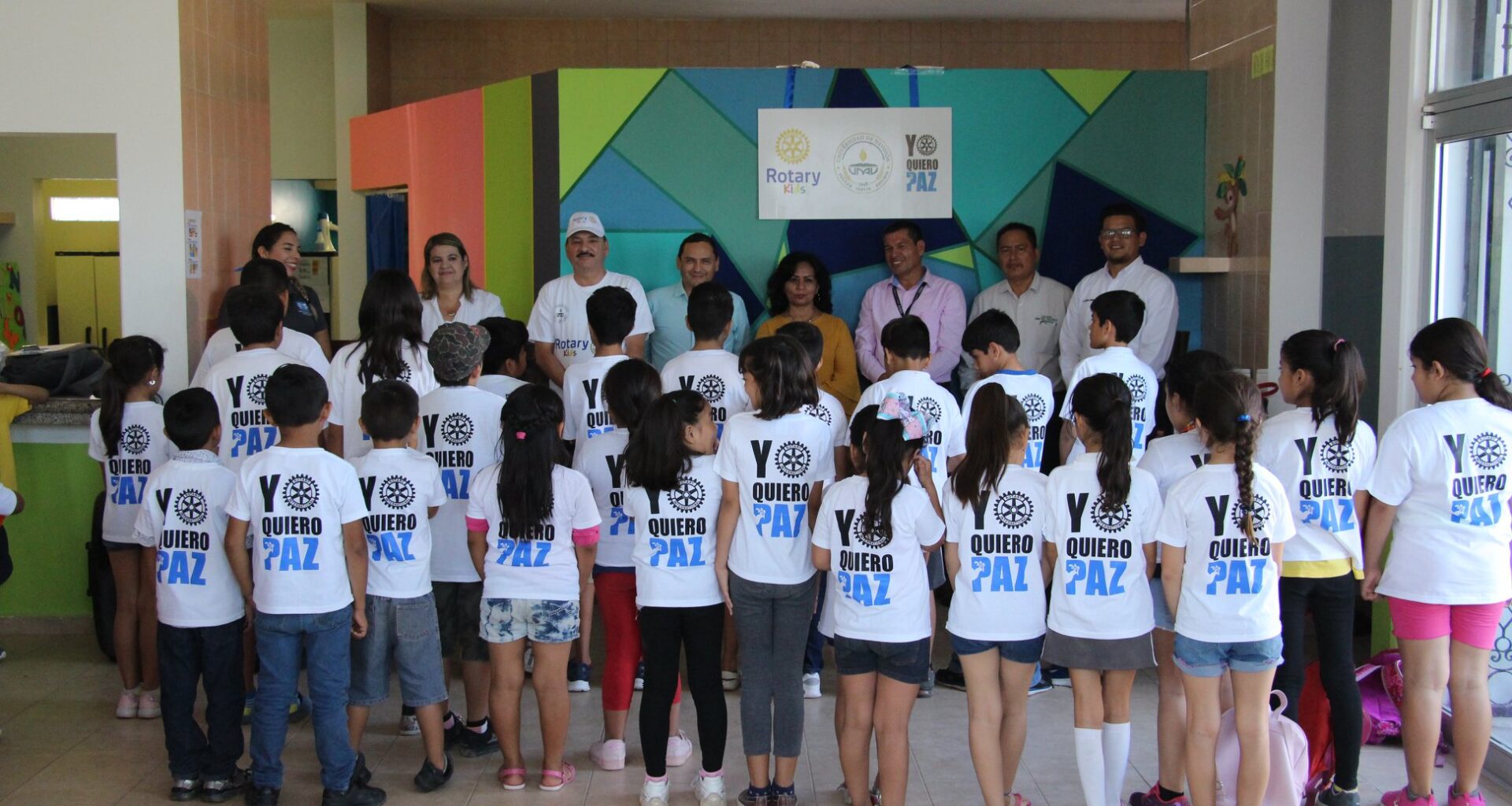 Grupo de niños y niñas con camisa color blanca y letras atras que dicen "Yo quiero paz"