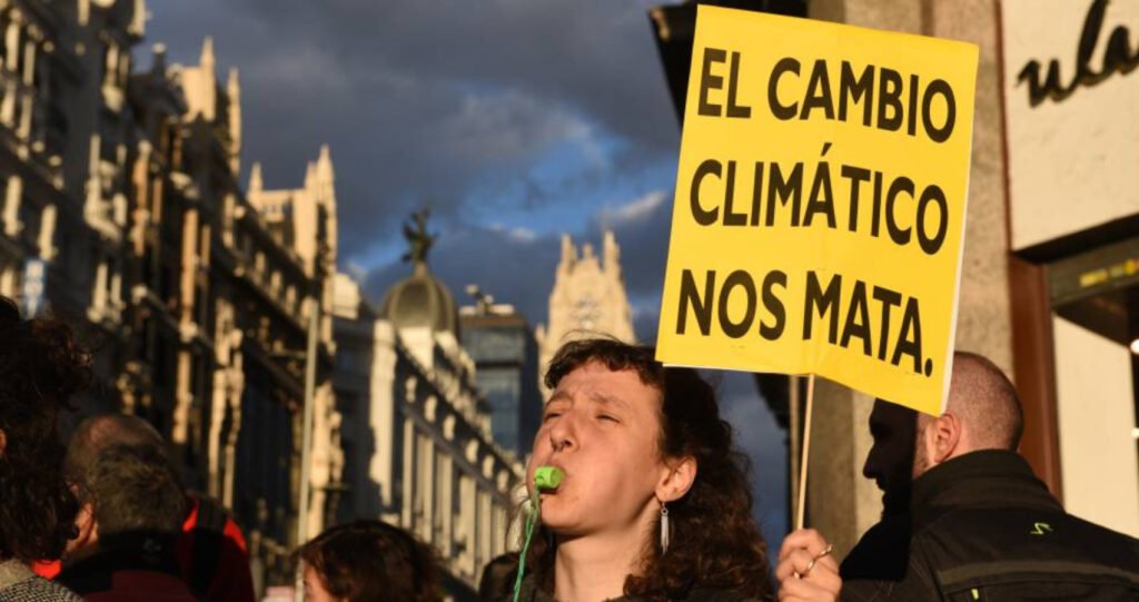 Mujer con pancarta del cambio climático.