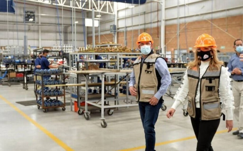Del lado derecho se encuentra un hombre y una mujer con casco color naranja, chaleco color crema con gris claro y pantalón oscuro. Generación de empleos en Sonora.