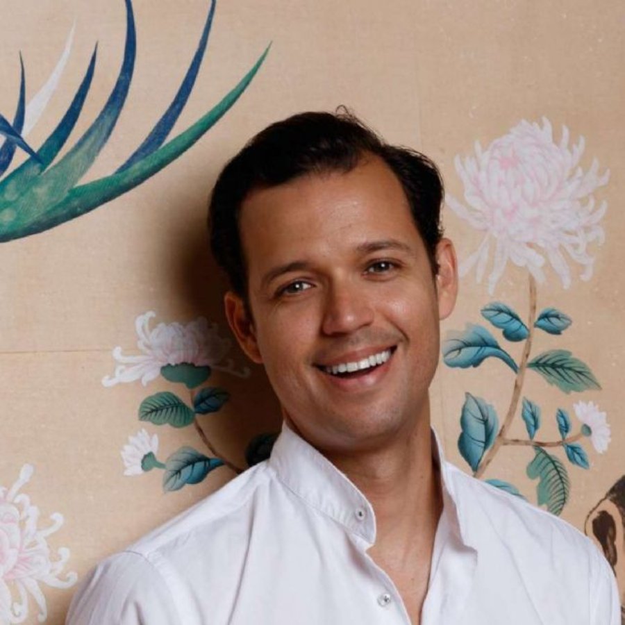 Diseñador sinaloense Andrés Romo; hombre con camisa blanca sonriendo 