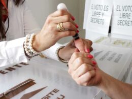 PREP 202Mano coloca tinta en el dedo a persona para emitir su voto en México