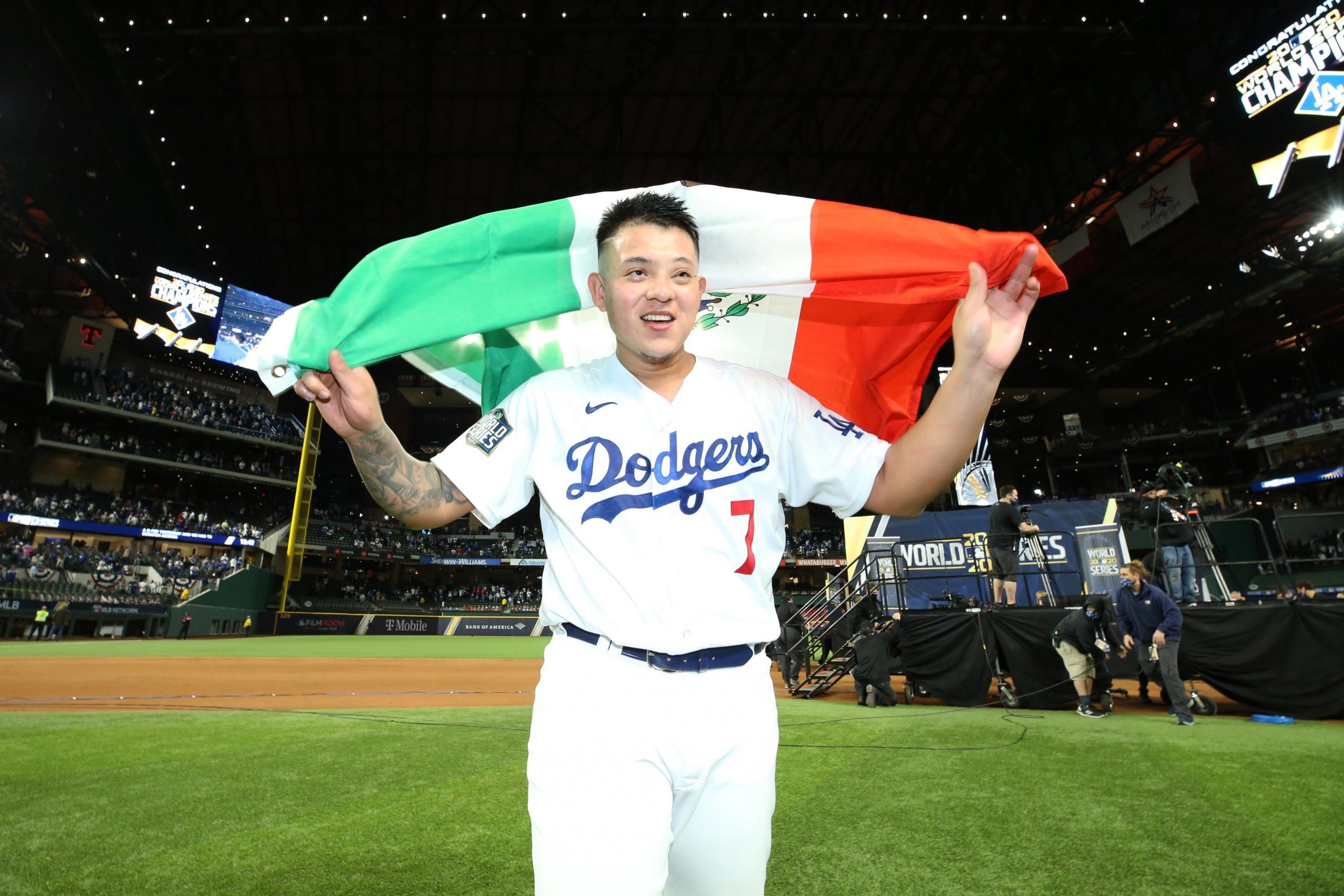 Julio Urías levantando bandera de México después de victoria con los Dodgers. 
