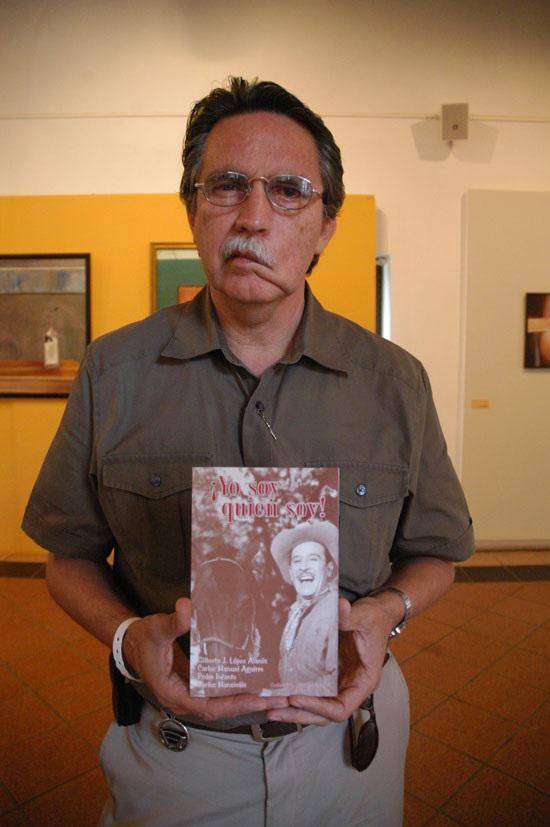 Gilberto López Alanís sosteniendo libro sobre el sinaloense Pedro Infante. 