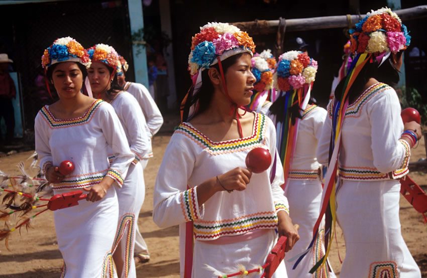 Mujeres de la etnia mayo con flores en la cabeza bailando una danza tradicional