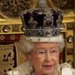 Reina Isabel II sentada en el trono y portando la corona de San Eduardo con perla