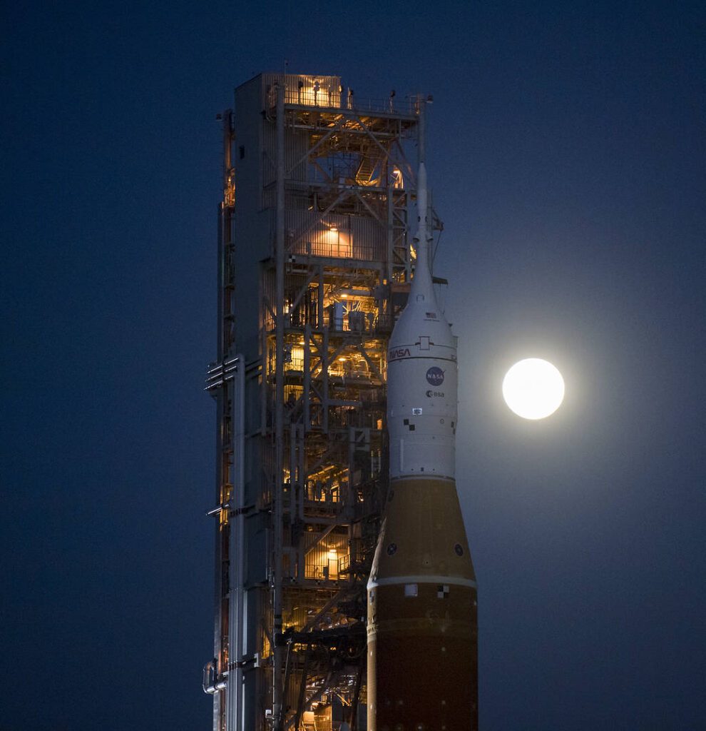 Cohete para la mision artemis I con la luna de fondo en el space kennedy center