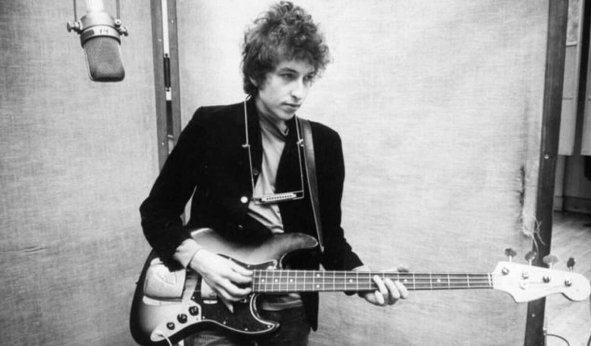 Foto en blanco y negro de Bob Dylan en los 70s tocando la guitarra y cantando