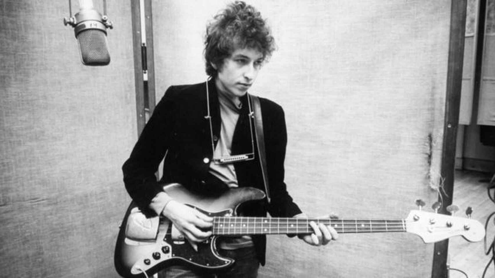 Foto en blanco y negro de Bob Dylan en los 70s tocando la guitarra y cantando