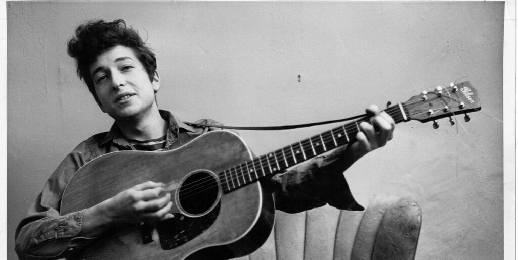 Foto en blanco y negro de Bob Dylan en los años setenta tocando la guitarra