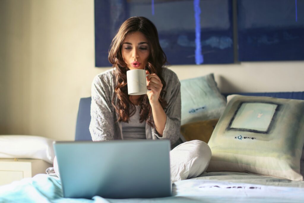 Mujer tomando cafe y trabajando en la laptop desde su casa. Desconexion digital