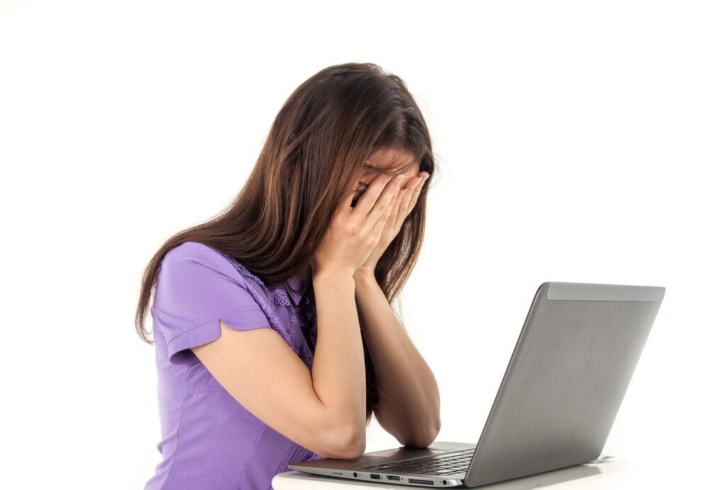 Mujer triste y llorando frente a la computadora mientras trabaja