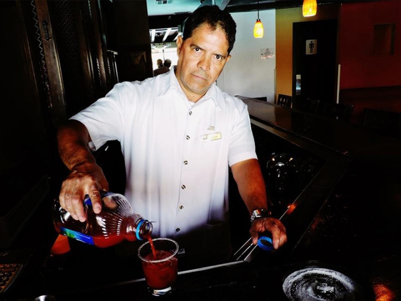Cantinero de bar de Mexicali sirviendo una famosa bebida Clamato