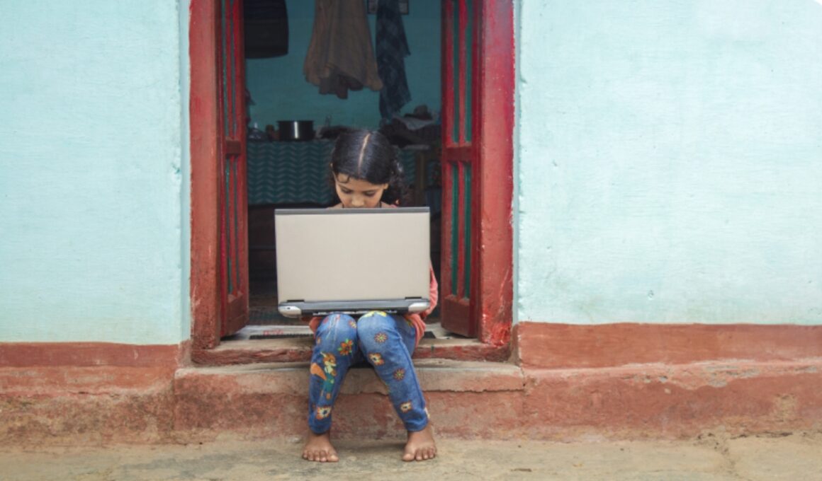 Una niña con una computadora en su regazo