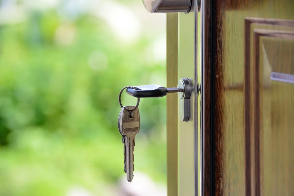 Imagen ilustrativa del sector inmobiliario: un par de llaves en una puerta abierta.
