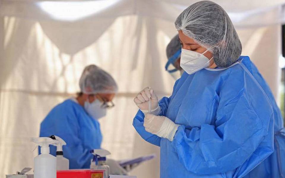 mujer en bata médica azul trabaja con una muestra de laboratorio