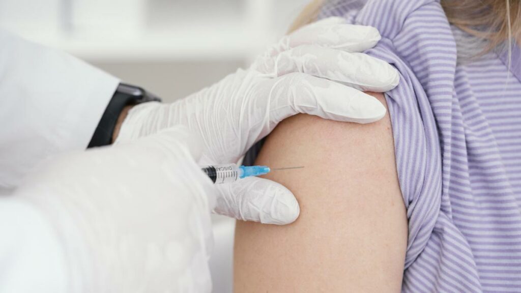 médico aplica vacuna en brazo de paciente